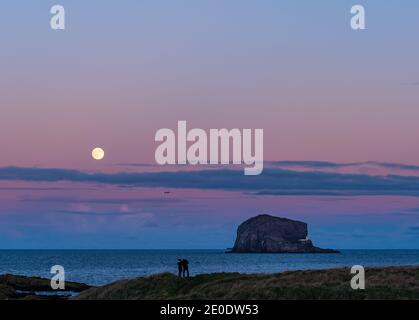 Ein Vollmond erhebt sich über Bass Rock Island mit einem bunten Sonnenuntergang, Firth of Forth, Schottland, Großbritannien Stockfoto