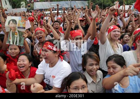 Aung San Suu Kyi und Anhänger der National League for Democracy (NLD) feiern ihren Sieg bei den Parlamentswahlen vor dem Parteihauptsitz am 1. April 2012 in Yangon, Myanmar. Tausende von Menschen mit einer außergewöhnlichen Vielfalt an Rassen, Alter und sozialen Hintergrund sahen zusammen die Ergebnisse auf einer Großleinwand mit dem lauten Klang von Rapp und Hip Hop Songs, um zum ersten Mal eine demokratische Wahl zu feiern. Foto von Christophe Lovigny/ABACAPRESS.COM Stockfoto