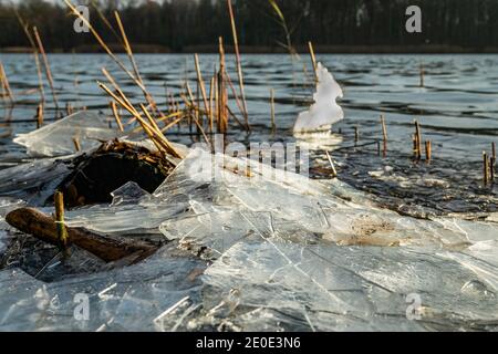 Dünne Eisstücke und ein leicht gefrorener See Ein sonniger Wintertag Stockfoto