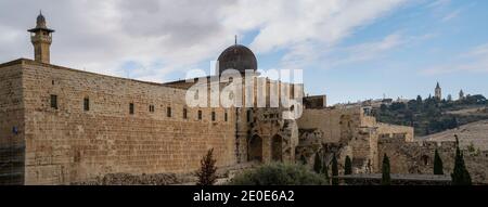 Jerusalem, Israel - 17. Dezember 2020: Die Al Aqsa Moschee überragt an einem teilweise bewölkten Tag die alten Stadtmauern. Stockfoto