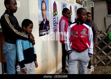 Kinder von einem Viertel von Les Ulis besuchen neben Plakaten des Wahlkampfes von Frankreichs Oppositionspartei (PS) Kandidat für die französische Präsidentschaftswahl 2012, Francois Hollande während eines Wahlkampfbesuchs in Les Ulis, außerhalb von Paris, Frankreich, am 7. April 2012. Foto von Stephane Lemouton/ABACAPRESS.COM. Stockfoto