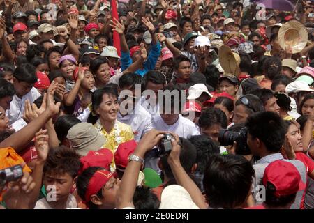 Die Demokratieführerin Aung San Suu Kyi und ihr Leibwächter sitzen unter ihren Unterstützern und schauen sich am ersten Tag des neuen Jahres ein Musikkonzert in Kawhmu an. Myanmar Nobelpreisträgerin Aung San Suu Kyi hat eine Nachwahl für das parlament gewonnen, sagt ihre Partei, nach einer wegweisenden Wahl, bei der 45 Sitze angefochten wurden. Frau Suu Kyis Oppositionsliga National League for Democracy (NLD) sagte, sie habe in Kawhmu leicht gewonnen. Kawhmu, Myanmar, 17. April 2012. Foto von Pyay Kyaw Myint/Jazz Editions/ABACAPRESS.COM Stockfoto