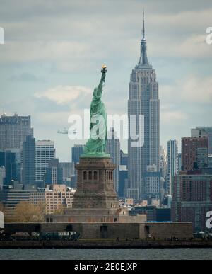 Space Shuttle Enterprise, montiert auf einem NASA 747 Shuttle Carrier Aircraft (SCA), wird in der Ferne hinter der Freiheitsstatue gesehen, Freitag, 27. April 2012, in New York. Enterprise war der erste Shuttle-Orbiter, der für die NASA gebaut wurde und Testflüge in der Atmosphäre durchführte und nicht in der Lage war, die Raumfahrt zu starten. Ursprünglich im Smithsonian's Steven F. Udvar-Hazy Center untergebracht, wird Enterprise vom SCA abgezerlegt und auf einem Lastkahn platziert, der schließlich im Juni mit einem Schleppboot den Hudson River hinauf zum Intrepid Sea, Air & Space Museum gebracht wird. Foto von Bill Ingalls/NASA via ABACAPRESS.COM Stockfoto