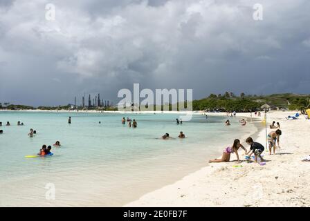 Baby Beach ist eine flache, geschützte Lagune in Seroe Colorado, an der Südostküste von Aruba, mit der Valero Ölraffinerie in Sicht. Stockfoto