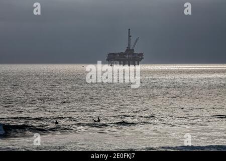 Oil Derrick und Surfer vor der Küste von Huntington Beach, Orange County, Kalifornien, USA Stockfoto