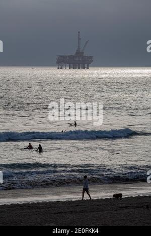 Oil Derrick und Surfer vor der Küste von Huntington Beach, Orange County, Kalifornien, USA Stockfoto