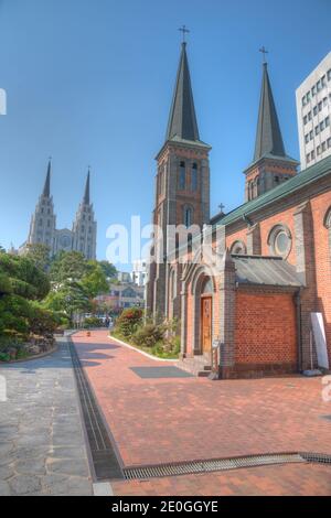 Jeil Kirche hinter der Kathedrale unserer Dame von Lourdes in Daegu, Republik Korea gesehen Stockfoto