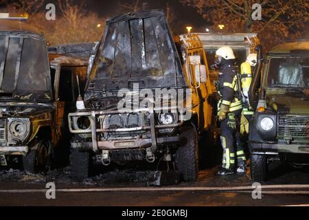 Leipzig, Deutschland. Dezember 2020. Auf dem Gelände eines Autohauses steht ein Feuerwehrmann bei ausgebrannten Offroad-Fahrzeugen der Bundeswehr. Nach ersten Erkenntnissen geht die Polizei von Brandstiftung aus. Quelle: Sebastian Willnow/dpa-Zentralbild/dpa/Alamy Live News Stockfoto