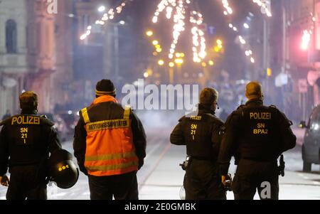 Leipzig, Deutschland. Dezember 2020. Polizisten und ein Sanitäter stehen an einer Kreuzung. Die Stadt Leipzig hatte zu Silvester Versammlungen verboten und in drei Zonen - darunter auch das Connewitzer Kreuz - ein Feuerwerkverbot erlassen. Quelle: Sebastian Willnow/dpa-Zentralbild/dpa/Alamy Live News Stockfoto