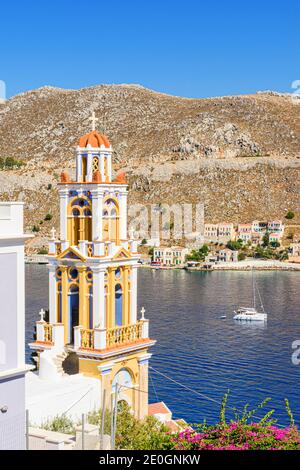 Der Glockenturm der Verkündigung-Kirche mit Blick auf die Südseite des Hafens von Gialos, Symi Island, Dodekanes, Griechenland Stockfoto