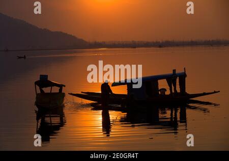 Srinagar, indisch kontrolliertes Kaschmir. Dezember 2020. Ein Bootsmann rudert sein Boot bei Sonnenuntergang in Srinagar, der Sommerhauptstadt von indisch-kontrolliertem Kaschmir, Dec. 31, 2020. Quelle: Javed Dar/Xinhua/Alamy Live News Stockfoto