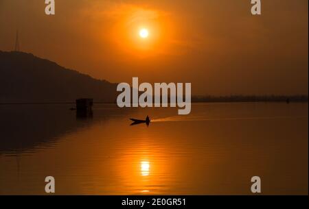 Srinagar, indisch kontrolliertes Kaschmir. Dezember 2020. Ein Bootsmann rudert sein Boot bei Sonnenuntergang in Srinagar, der Sommerhauptstadt von indisch-kontrolliertem Kaschmir, Dec. 31, 2020. Quelle: Javed Dar/Xinhua/Alamy Live News Stockfoto