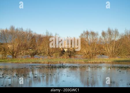 Überflutete Felder entlang des Flusses windrush rund um das cotswold Dorf Swinbrook am heiligabend 2020. Swinbrook, Cotswolds, Oxfordshire, England Stockfoto