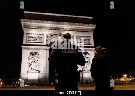 Paris, Frankreich. Dezember 2020. Polizeibeamte gehen zur Kontrolle während der Ausgangssperre am neuen Jahr Tag vor dem Arc de Triomphe in den Champs Elysees, Paris, Frankreich, 1. Januar 2021. Quelle: ABACAPRESS/Alamy Live News Stockfoto