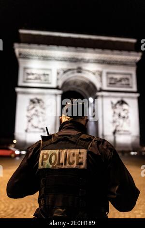 Paris, Frankreich. Dezember 2020. Polizeibeamte gehen zur Kontrolle während der Ausgangssperre am neuen Jahr Tag vor dem Arc de Triomphe in den Champs Elysees, Paris, Frankreich, 1. Januar 2021. Quelle: ABACAPRESS/Alamy Live News Stockfoto