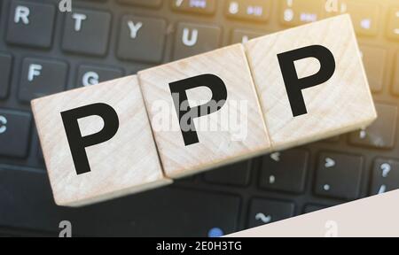 Drei Holzwürfel mit den Buchstaben PPP (steht für Praise Picture Push) auf der Computertastatur. Marketing-Geschäftskonzept. Stockfoto