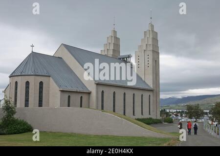 Akureyri, Island - 27. Juli 2017: Die Rückseite der Akureyrarkirkja Kirche in Akureyri in Island und Leute, die für den Gottesdienst gehen. Stockfoto