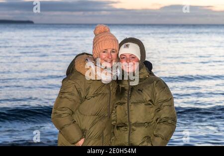 Myrtleville, Cork, Irland. Januar 2021. Maura Duffy und Áine King aus Agamartha am Strand, um den Sonnenaufgang am Neujahrstag in Myrtleville, Co. Cork, Irland, zu begrüßen. - Credit; David Creedon / Alamy Live News Stockfoto