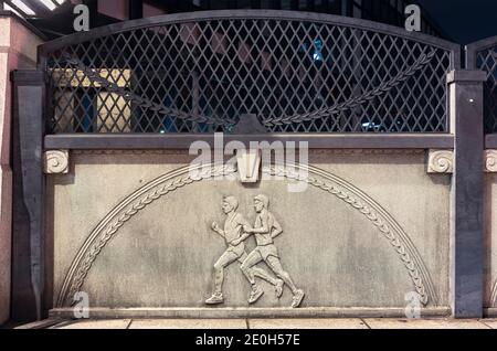 tokio, japan - november 02 2020: Nahaufnahme eines Steinreliefs, das Athleten beim Marathonlauf auf der Olympischen Brücke von Harajuku namens Gorinb zeigt Stockfoto