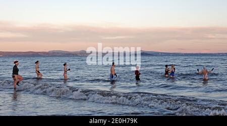 Portobello, Edinburgh, Schottland, Großbritannien. Januar 2021. Neujahrstag Dip bei Sonnenaufgang, Temperatur 1 Grad Celsius. Porty Loony Dook nicht stattfinden aufgrund der Pandemie so separate Gruppen genießen ihre eigenen Neujahr schwimmen im Firth of Forth. Quelle: Arch White/Alamy Live News. Stockfoto