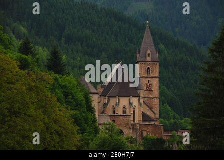 Schöne alte Kirche in der Mitte der Berge mit Viele Bäume auf der rechten Seite Stockfoto