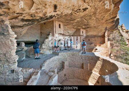 Besucher über Kiva (zeremonielle Kammer) im Balcony House Cliff Dwelling, Cliff Palace Loop, Mesa Verde National Park, Colorado, USA Stockfoto