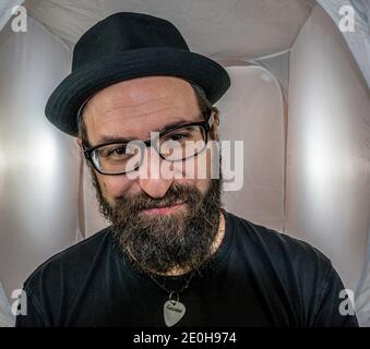 Ein bärtig lächelnder Mann in guter Stimmung mit Schwarz Brille Stockfoto