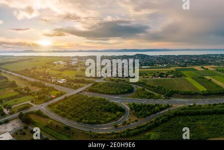 Landschaft mit Balatonboglar und Autobahn M7. Die Autobahnausfahrt hat die Form eines B-Zeichens. Der Plattensee im Hintergrund Stockfoto