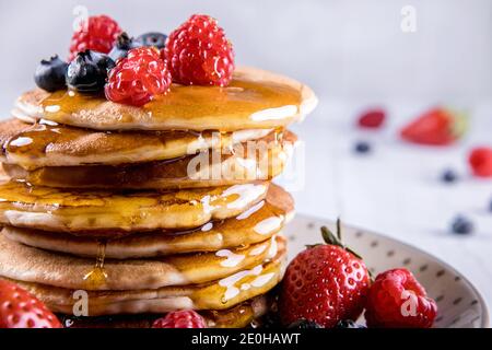 Stapel von amerikanischen Pfannkuchen mit Obst und Sirup Stockfoto