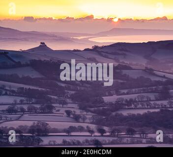 Lamberts Castle, Dorset, Großbritannien. Januar 2020. Wetter in Großbritannien: 2021 beginnt herrlich, wenn die Sonne über einem frostigen Marshwood Vale aufgeht, mit Colmers Hill, Portland und Chesil Beach in der Ferne. Kredit: Celia McMahon/Alamy Live Nachrichten Stockfoto