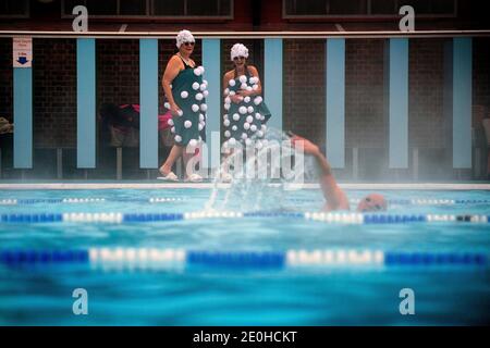 Jessica Walker und Nicola Foster, bekannt als die Lido Ladies, bereiten sich auf eine frühmorgendliche Schwimmerin bei einer Schneedusche im Charlton Lido im Hornfair Park, London, vor. Stockfoto