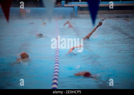 Am frühen Morgen Schwimmer in einer Schneedusche bei Null-Grad-Temperaturen in Charlton Lido in Hornfair Park, London. Stockfoto