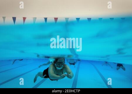 Ein Schwimmer am frühen Morgen bei Null-Grad-Temperaturen in Charlton Lido im Hornfair Park, London. Stockfoto