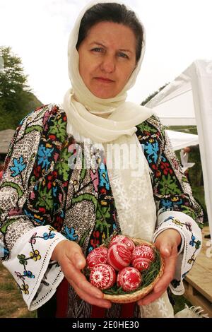 Buzau County, Rumänien. Frau in schönen handgenähten traditionellen Kleidung mit Korb mit verzierten Ostereiern. Stockfoto