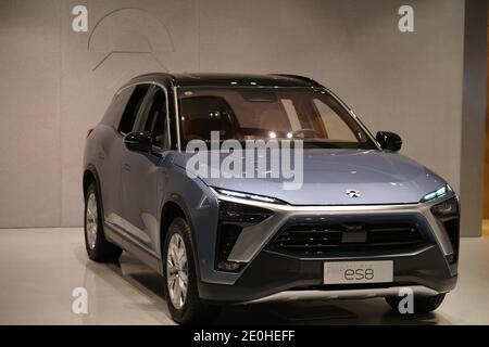 Shanghai.China-Dez.2020: NIO's ES8 Elektroauto im Geschäft. NIO's Logo an der Wand. NIO ist ein chinesischer Elektroautomobilhersteller Stockfoto