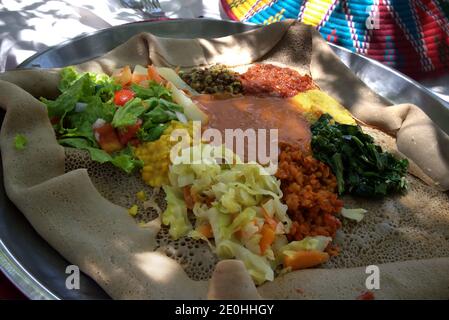 Traditionelles Gericht von gemischten Gemüseprobenehmern auf einem Bett von Injera Fladenbrot Stockfoto