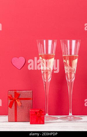 Valentine´s Day Komposition mit zwei Gläsern Champagner, Herz und Geschenke auf rotem Hintergrund. san Valentin und Love Konzept. Stockfoto