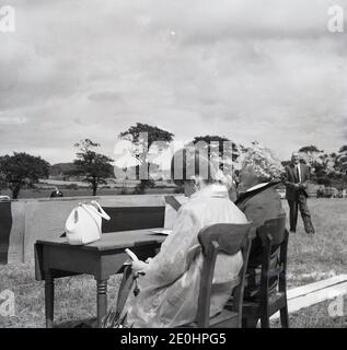 1960er, historisch, Scocrers an einer Bank, bei den Highland Games, Schottland, sitzen draußen bei der Tanzbühne. Stockfoto