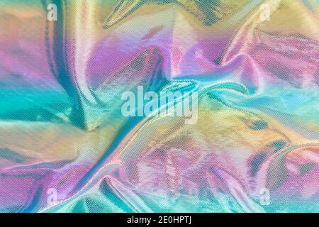 Holografische irisierende Oberfläche faltige Folie Pastell. Real Hologramm Hintergrund von zerknitterten abstrakten Folie 80er Jahre Textur Stockfoto