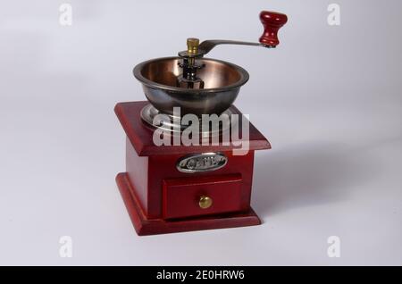 Rote Kaffeemühle im Vintage-Stil auf weißem Hintergrund. Stockfoto