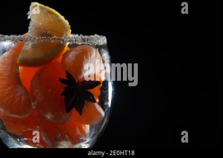 Fruit Dessert in einem Glas Mandarinen, Zitrone und Kokosnuss in Glas auf schwarzem Hintergrund mit einem Platz für die Beschriftung. Stockfoto