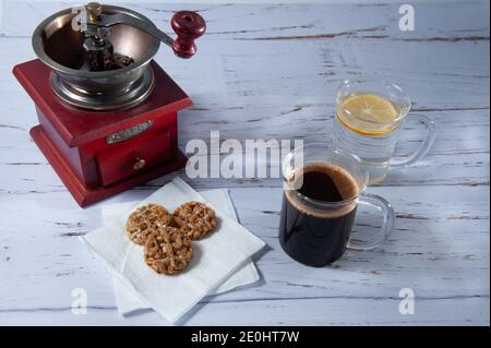 tasse Kaffee und Wasser mit Zitrone und Keksen auf Ein leicht strukturiertes Telefon Stockfoto