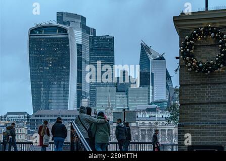 Menschen, die vor den Bürogebäuden der City of London stehen, einschließlich der Walkie Talkie, der Skalpell und der Cheesegrater, in der Dämmerung, London, Großbritannien Stockfoto