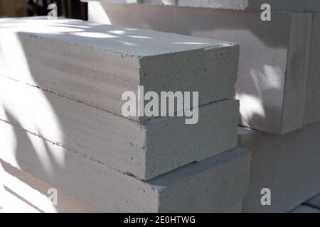 Blöcke aus Porenbeton werden übereinander gestapelt. Baumaterial für Gebäude. Große weiße Ziegel Stockfoto