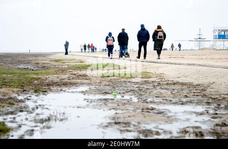 Dangast, Deutschland. Januar 2021. Zahlreiche Wanderer sind am Strand von Dangast am Neujahrstag bei bewölktem Wetter. Quelle: Hauke-Christian Dittrich/dpa/Alamy Live News Stockfoto