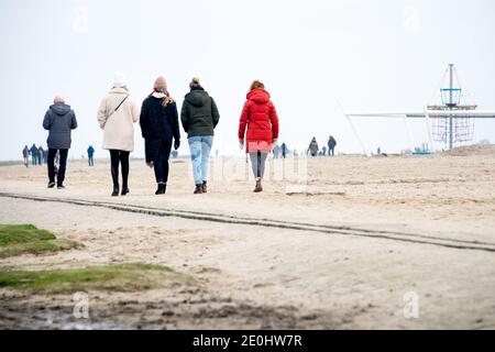 Dangast, Deutschland. Januar 2021. Zahlreiche Wanderer sind am Strand von Dangast am Neujahrstag bei bewölktem Wetter. Quelle: Hauke-Christian Dittrich/dpa/Alamy Live News Stockfoto