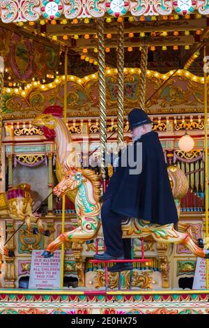 Viktorianischer Polizist, der auf dem Karussell reitet, beim Victorian Festival of Christmas in Portsmouth, Hants England im Dezember Stockfoto