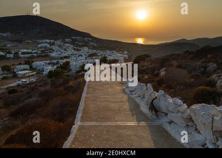 Chora, Insel Folegandros, Griechenland - 23. September 2020: Sonnenuntergang über der Altstadt von Chora. Blick auf die traditionellen griechischen Gebäude und die Küste. Stockfoto