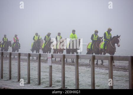 Bild vom 31. Dezember zeigt Jockeys auf den Rennpferden, die auf Newmarket Galopps in Suffolk trainieren, bei einem eisigen und nebligen Start in die Silvesternacht.Schnee wird für einige Teile Großbritanniens in den nächsten Tagen prognostiziert. Stockfoto