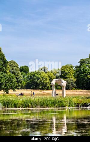 People Walking und "The Arch" Skulptur von Henry Moore im Hyde Park, London, Großbritannien Stockfoto